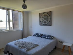 Dormitorio principal amoblado con cama de dos plazas y ventana de termopanel.