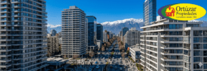 Edificios de departamentos nuevos en Santiago representando el crecimiento inmobiliario y el logo de Ortúzar Propiedades.